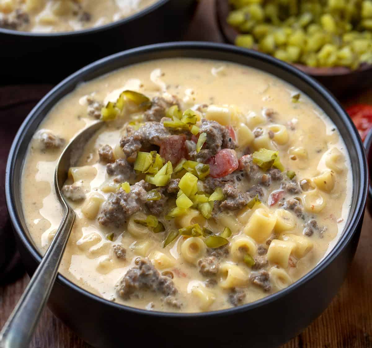 Black bowl of Cheeseburger Pasta Soup with a spoon in it close up Black bowl of Cheeseburger Pasta Soup with a spoon in it close up.