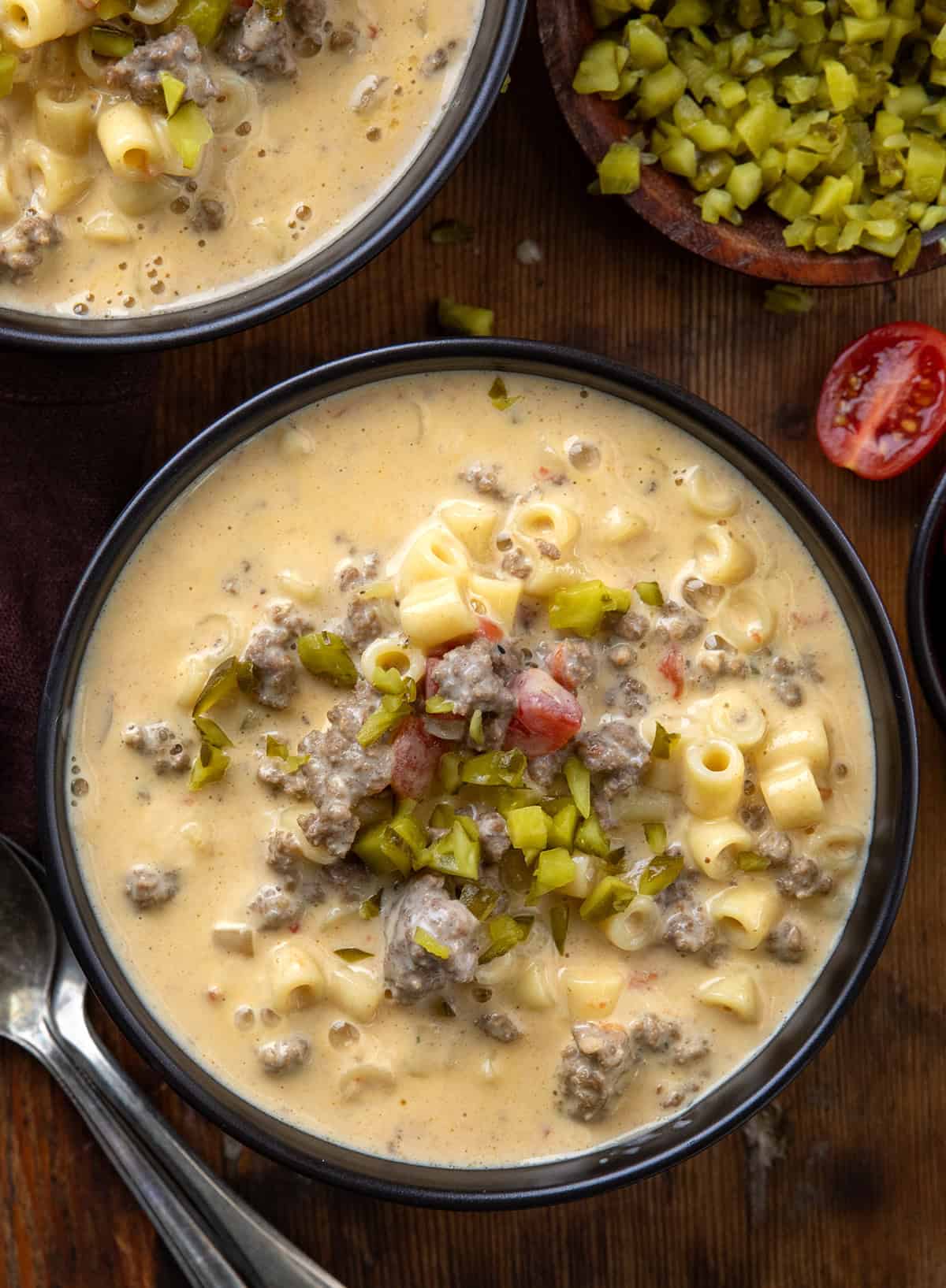 Black bowls of Cheeseburger Pasta Soup on a wooden table from overhead Black bowls of Cheeseburger Pasta Soup on a wooden table from overhead.