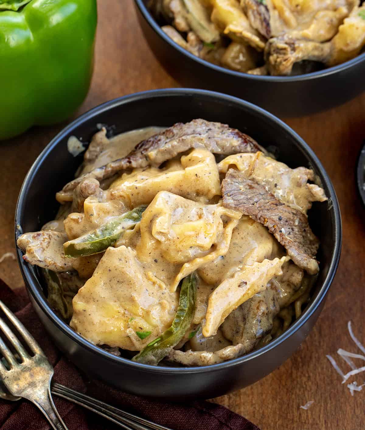 Bowls of Cheesesteak Tortellini on a wooden table close up Bowls of Cheesesteak Tortellini on a wooden table close up.