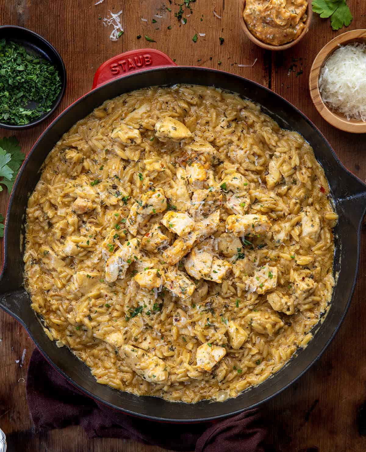 Skillet of Cowboy Butter Chicken Orzo on a wooden table from overhead Skillet of Cowboy Butter Chicken Orzo on a wooden table from overhead.