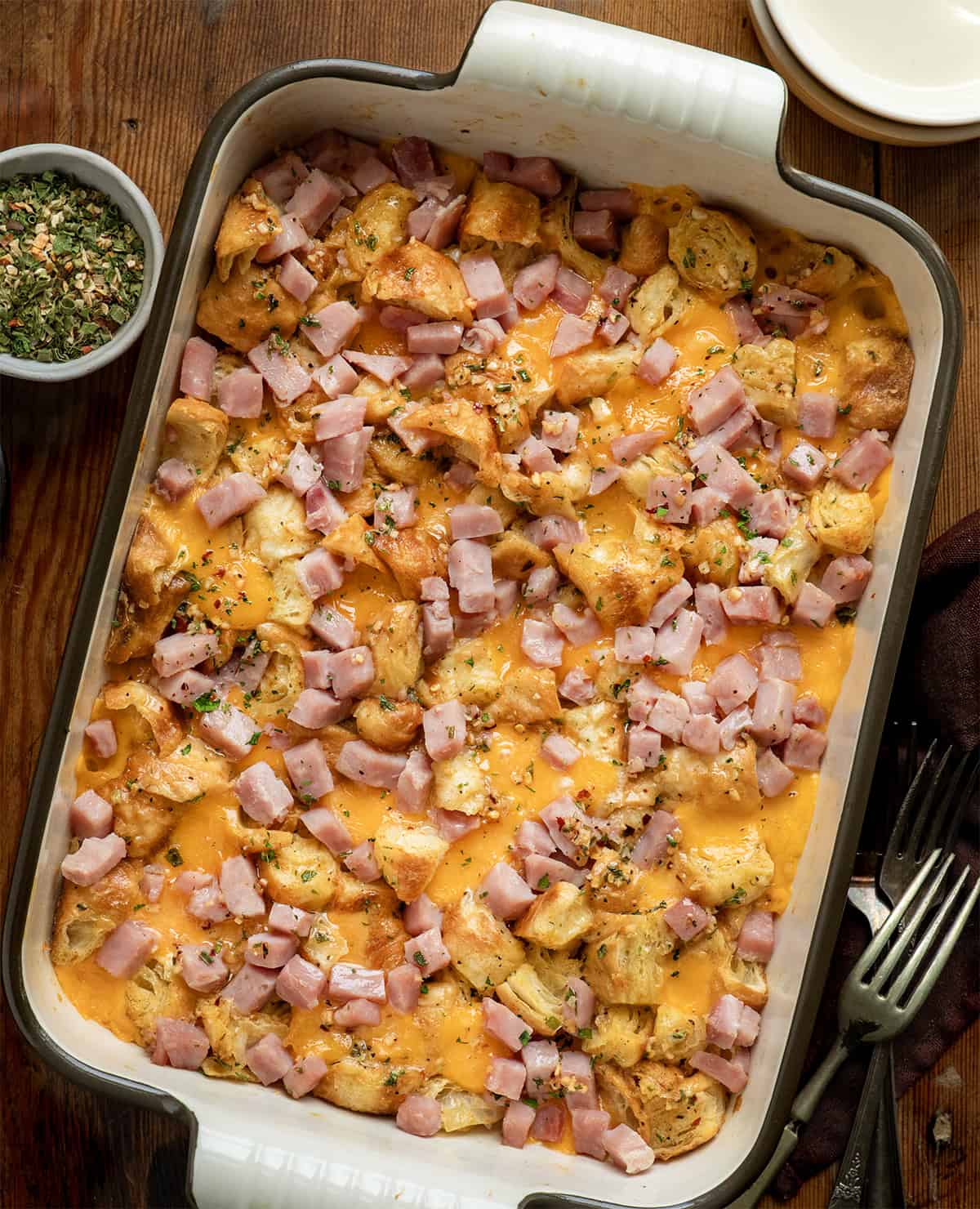 Cowboy Butter Ham and Cheese Croissant Bake on a wooden table from overhead.