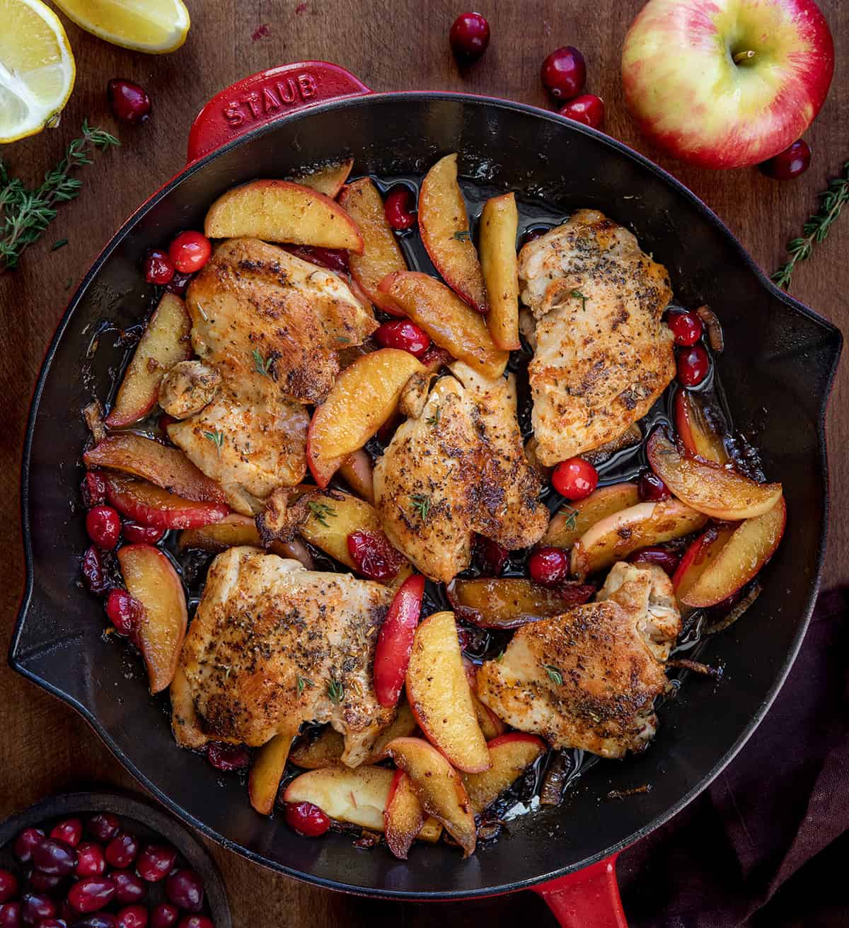 Skillet of Cranberry Apple Orchard Chicken on a wooden table from overhead Skillet of Cranberry Apple Orchard Chicken on a wooden table from overhead.