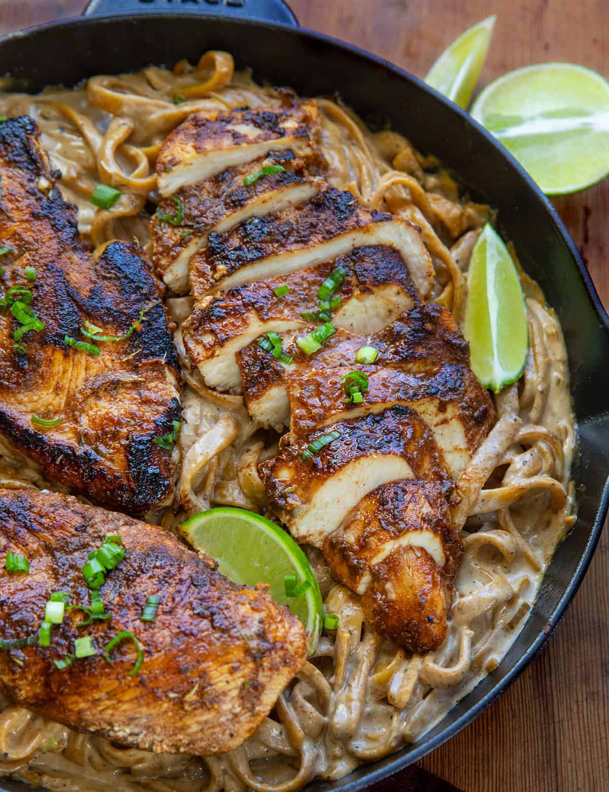 Close up of Jerk Chicken that is sliced on top of Alfredo fettuccine Close up of Jerk Chicken that is sliced on top of Alfredo fettuccine.