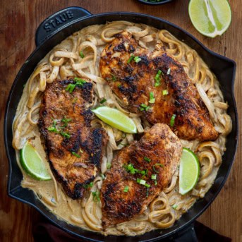 Jerk Chicken Alfredo on a wooden table from overhead.