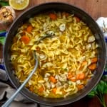 Pot of Roasted Garlic Chicken Noodle Soup with a ladle in it from overhead.