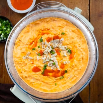 Slow Cooker Buffalo Chicken Dip on a wooden table from overhead.