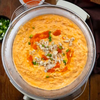 Slow Cooker Buffalo Chicken Dip on a wooden table from overhead.