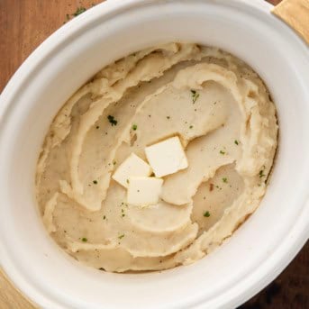 Slow Cooker Mashed Potatoes on a wooden table from overhead.