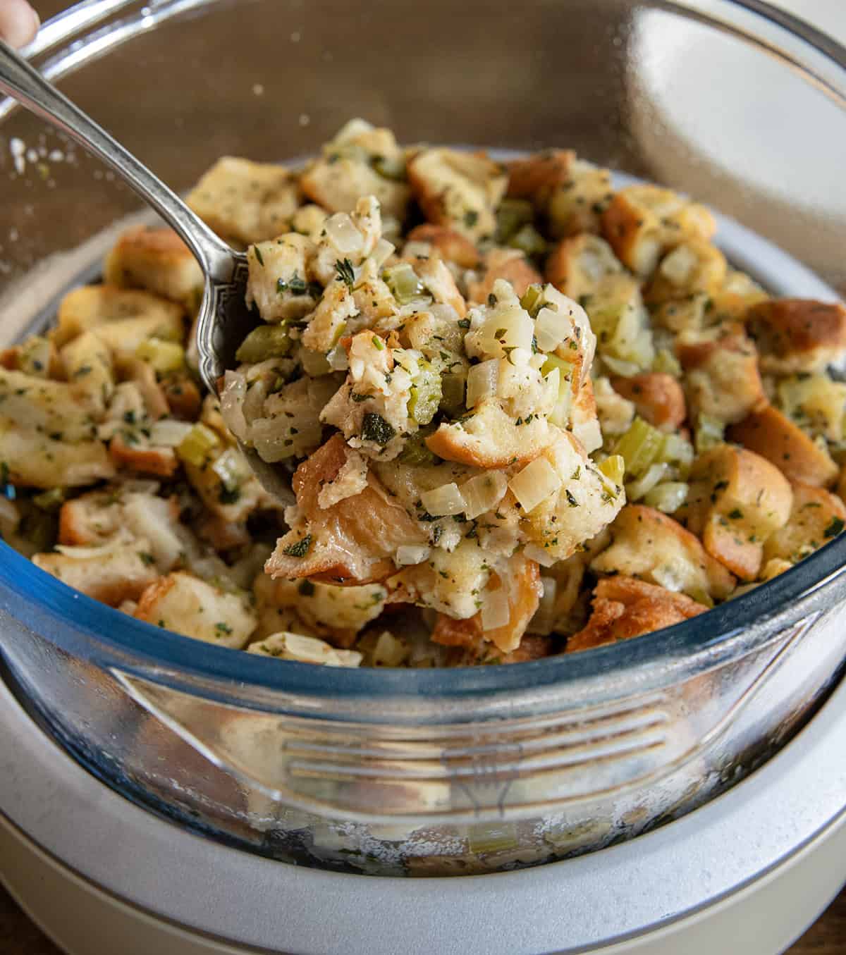 Spoonful of stuffing being held above the crockpot Spoonful of stuffing being held above the crockpot.